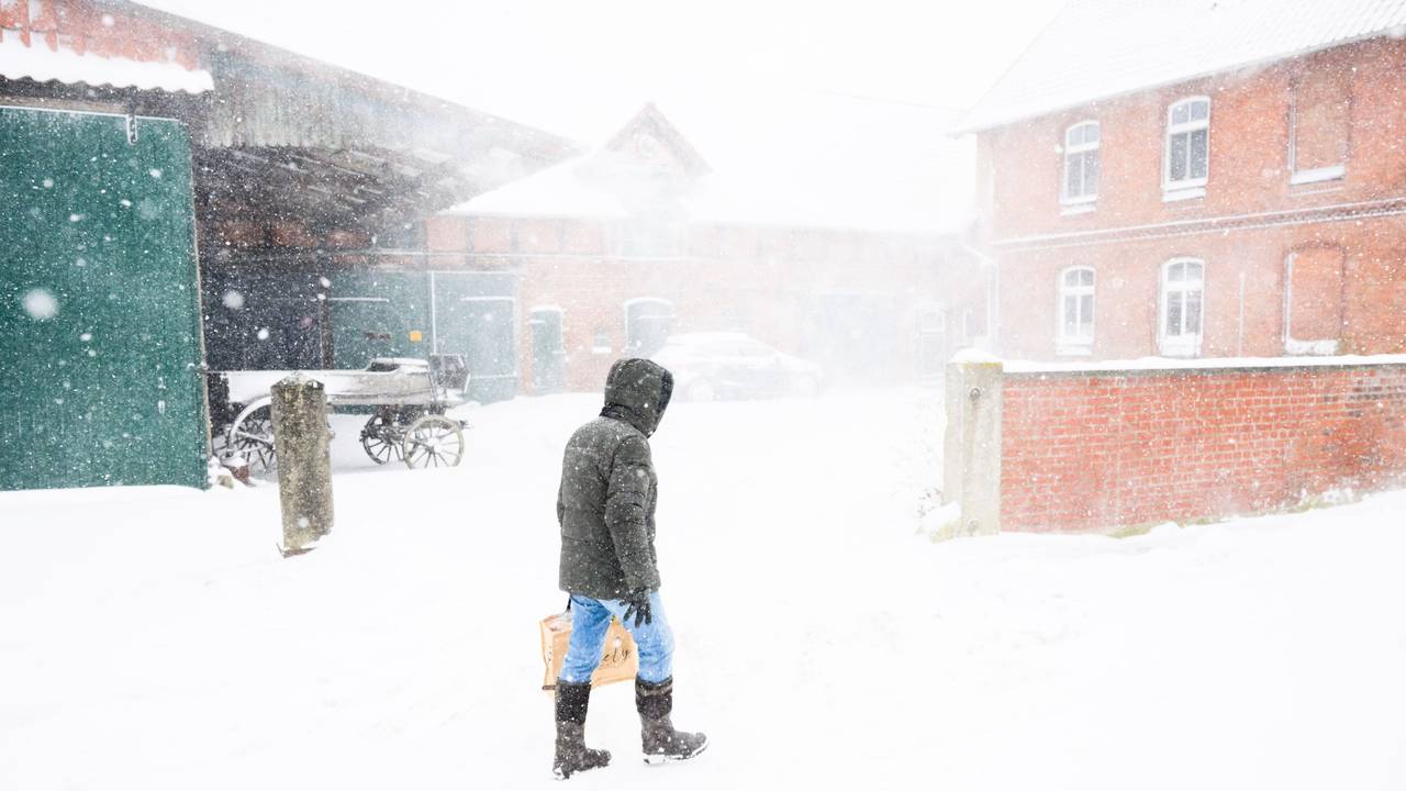 09.01.2026, Niedersachsen, Laatzen: Ein Mann geht beim Schneesturm an einem Hof in der Region Hannover vorbei. Foto: Julian Stratenschulte/dpa +++ dpa-Bildfunk +++