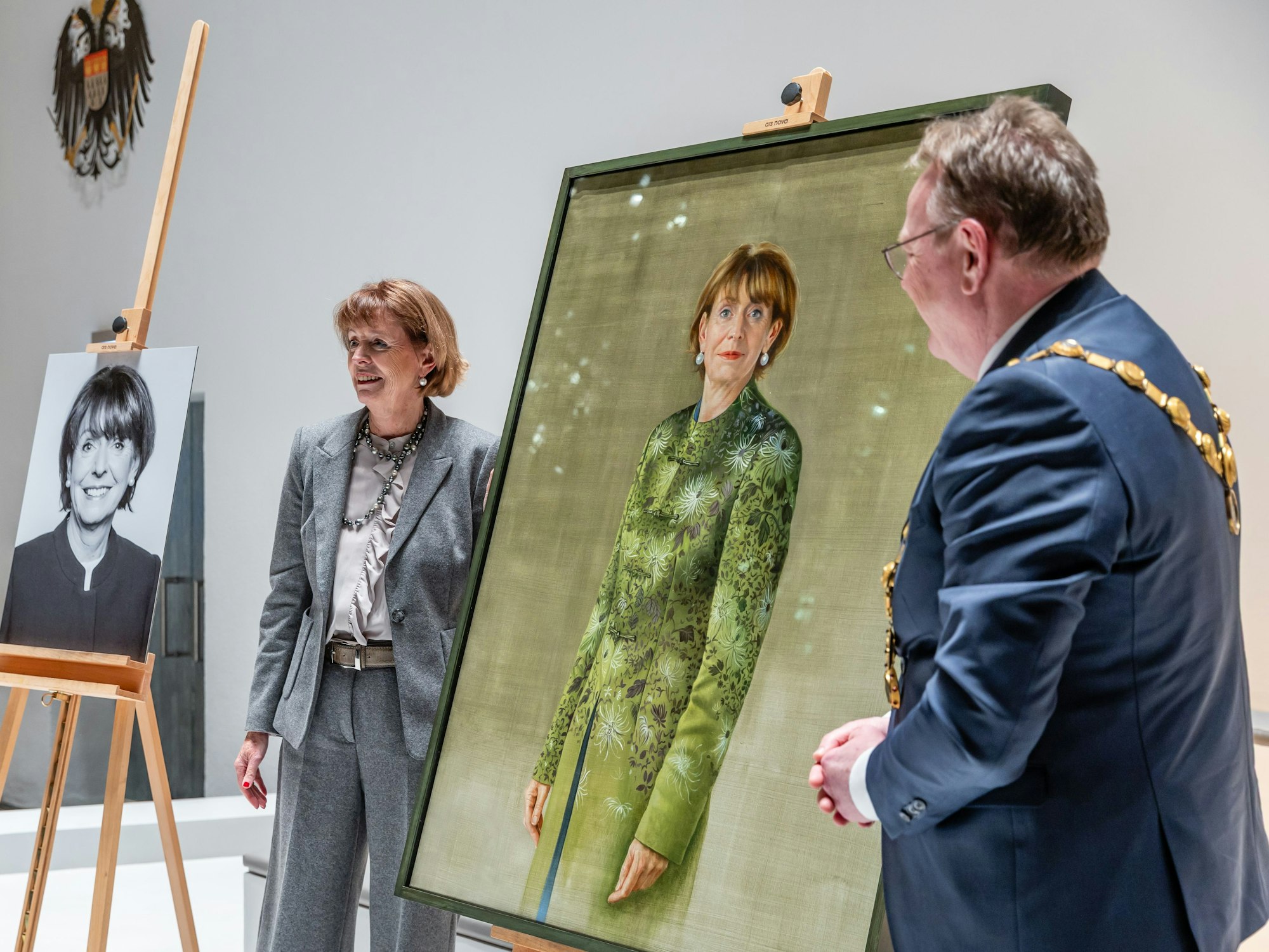 Henriette Reker zwischen den beiden Porträts, die künftig neben Ratssaal und Amtszimmer hängen sollen. Rechts im Foto: Kölns OB Torsten Burmester.