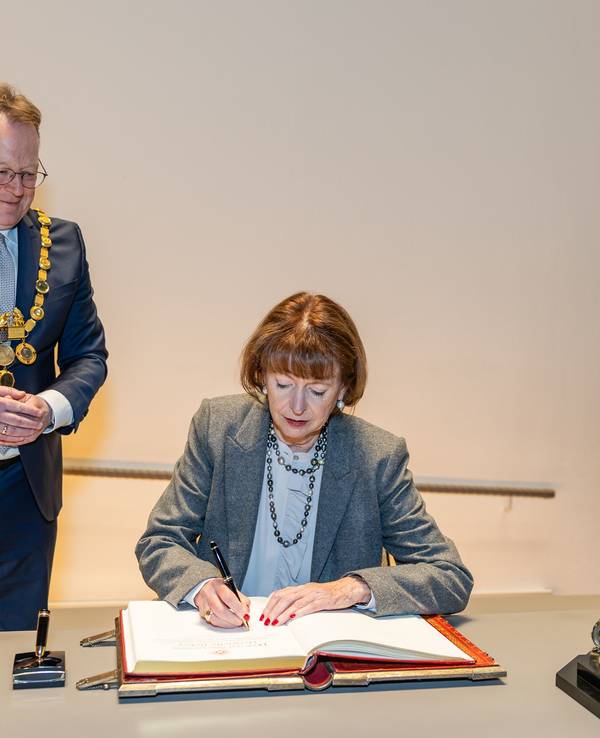 Henriette Reker trägt sich in Anwesenheit ihres Amtsnachfolgers Torsten Burmester ins Goldene Buch der Stadt Köln ein.