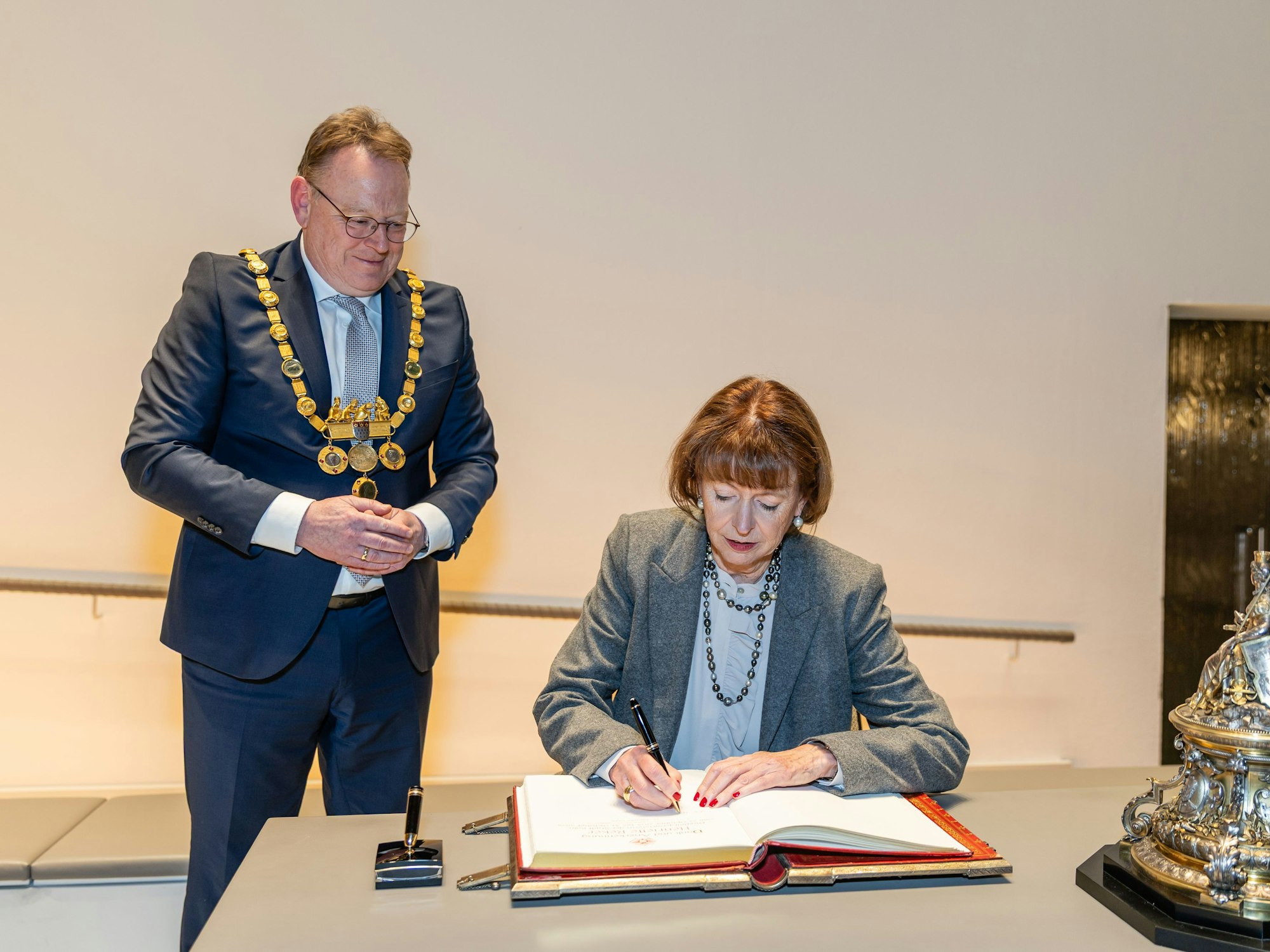 Henriette Reker trägt sich in Anwesenheit ihres Amtsnachfolgers Torsten Burmester ins Goldene Buch der Stadt Köln ein.