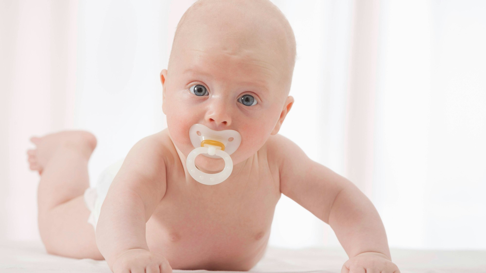 Neugeborenes Baby mit Schnuller auf Decke