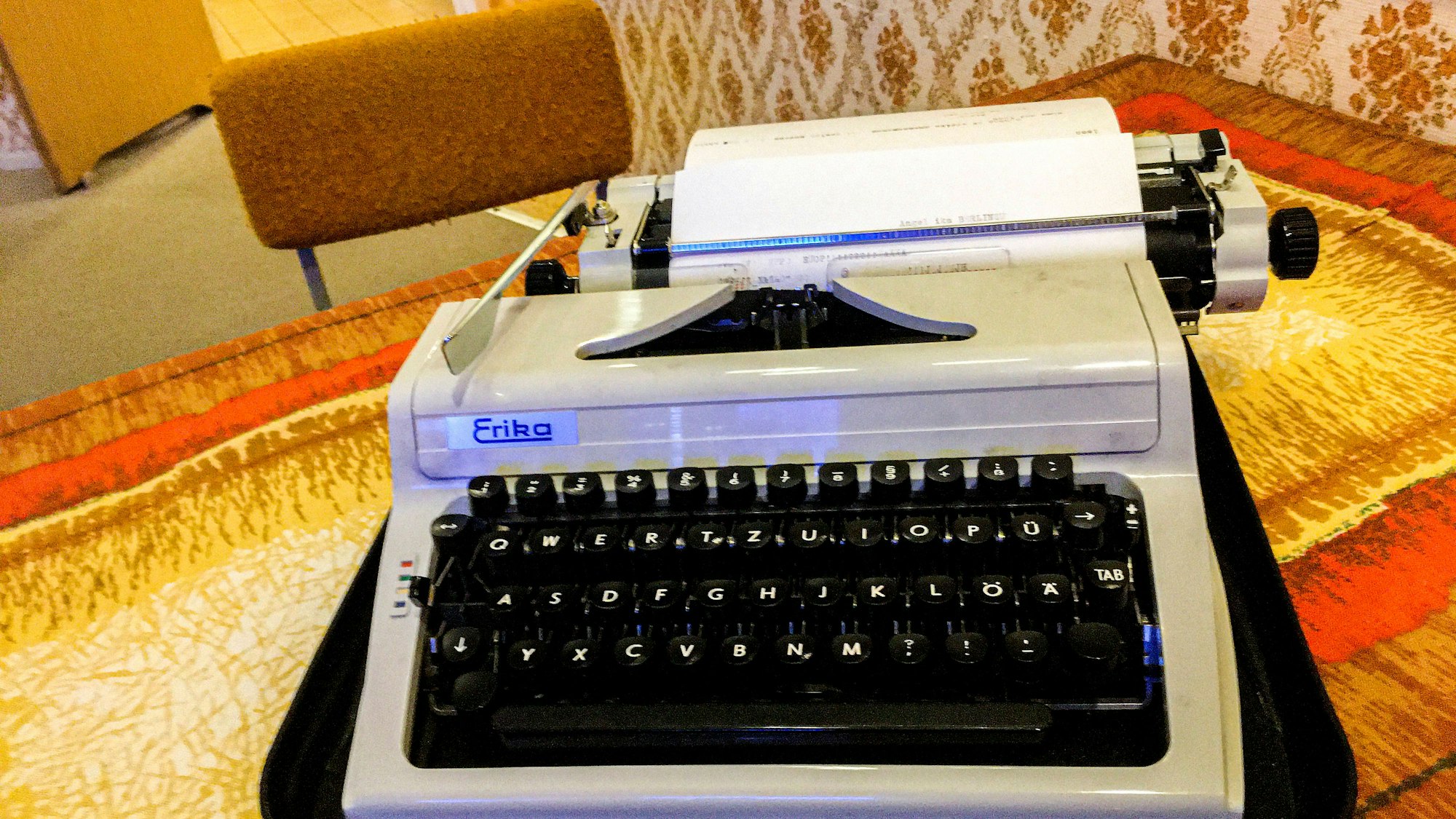 Schreibmaschine, Möbel und gemusterte Wand im Raum