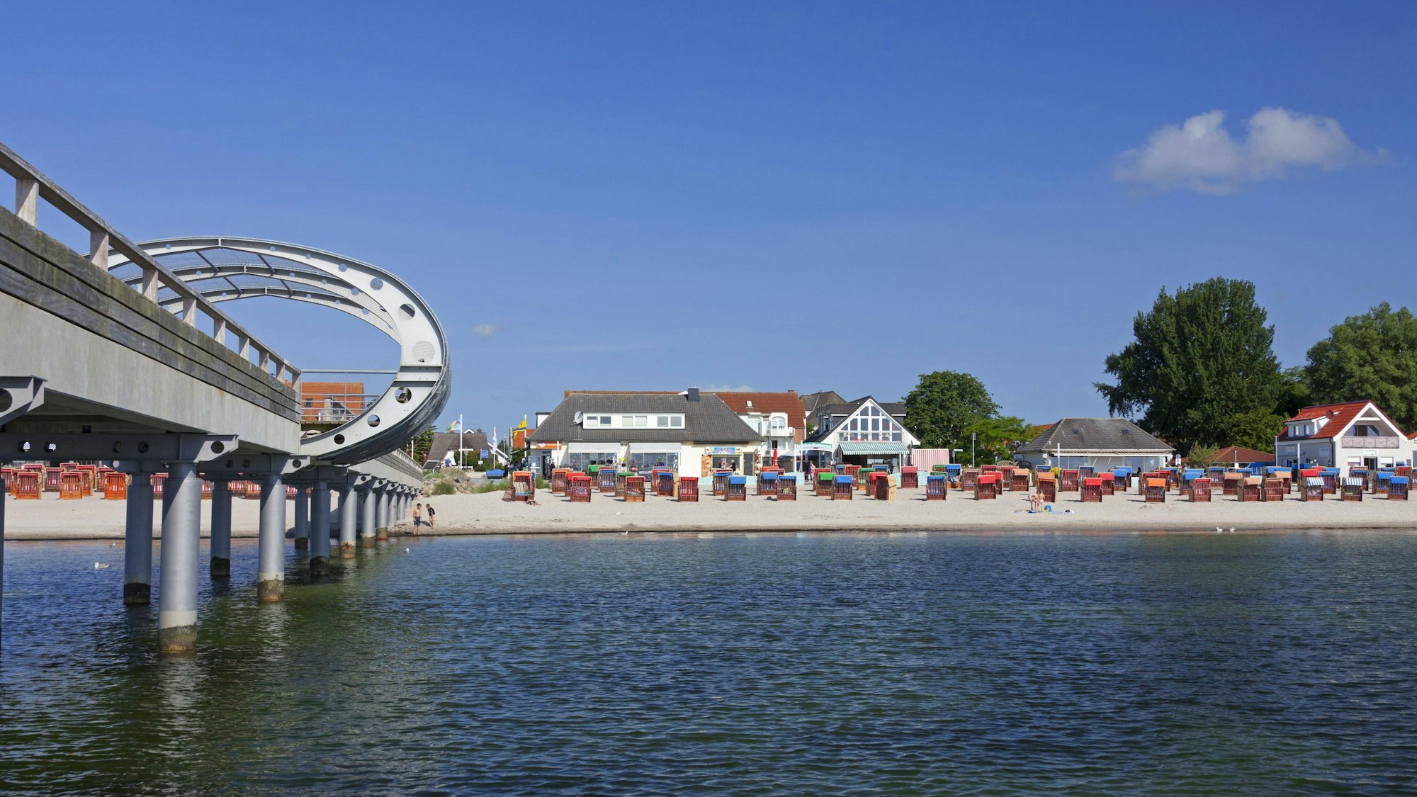 Seebrücke, Strand mit Strandkörben, Wasser und Gebäuden