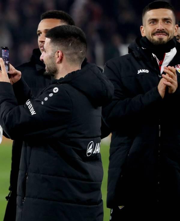 Deniz Undav (r.) filmt seinen Teamkollegen Nikolas Nartey beim Jubel in der Fankurve nach dem Spiel gegen Eintracht Frankfurt.