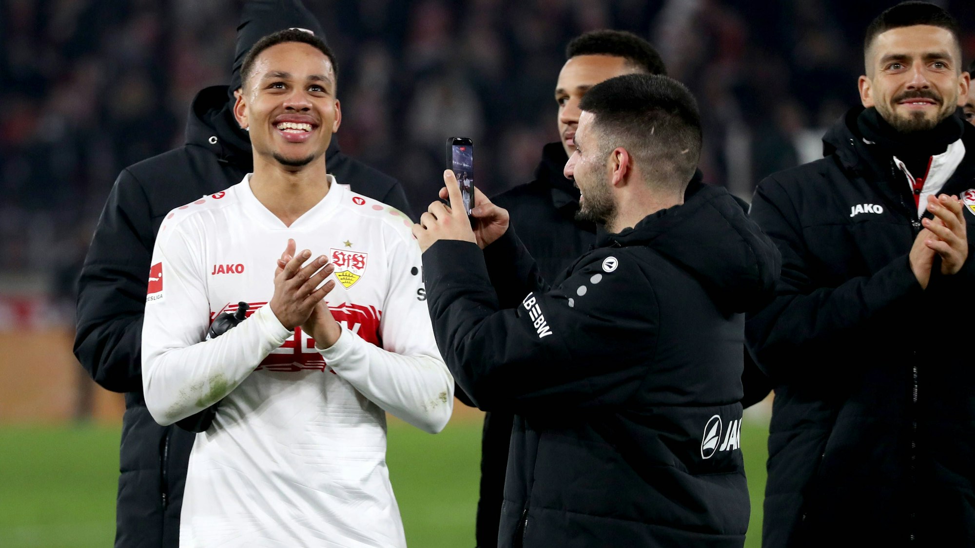 Deniz Undav (r.) filmt seinen Teamkollegen Nikolas Nartey beim Jubel in der Fankurve nach dem Spiel gegen Eintracht Frankfurt.