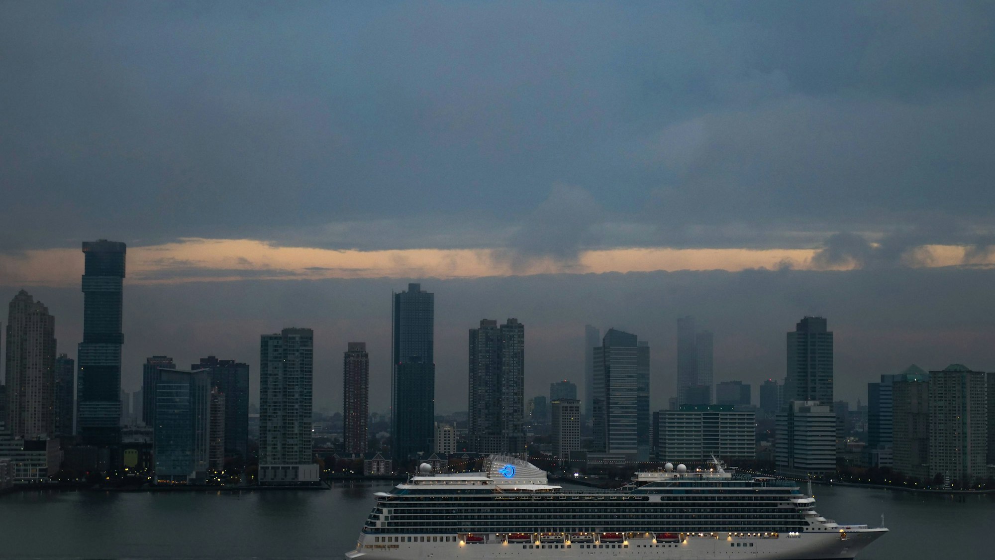 Ein Kreuzfahrtschiff vor einer Stadtkulisse am Wasser