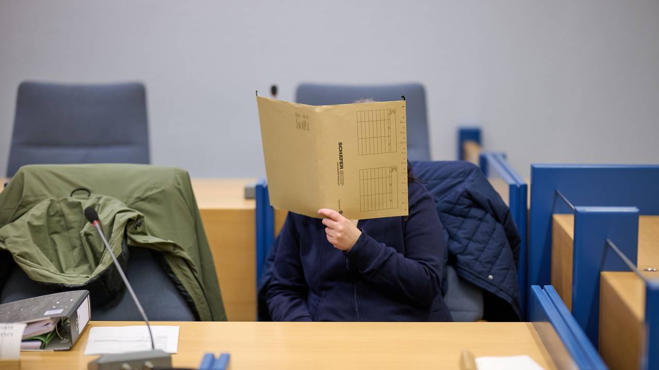Eine angeklagte Mutter verbirgt im Gerichtssaal ihr Gesicht hinter einer Akte. Sieben Jahre lang und schon vom Babyalter an soll die Frau ihre Tochter im Haus der Großeltern in Attendorn in Nordrhein-Westfalen festgehalten haben - versteckt und vollständig abgeschottet von der Außenwelt.