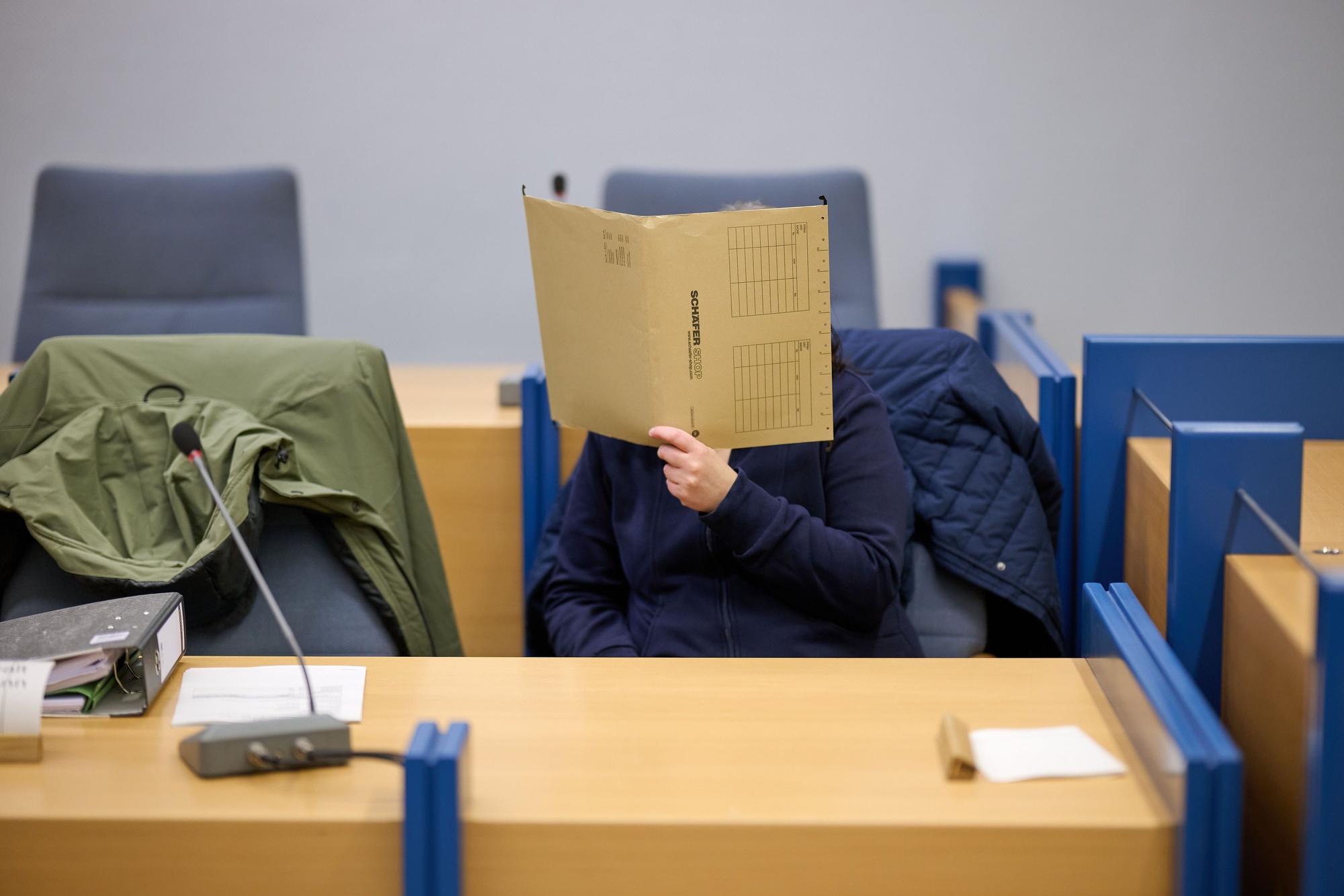 Eine angeklagte Mutter verbirgt im Gerichtssaal ihr Gesicht hinter einer Akte. Sieben Jahre lang und schon vom Babyalter an soll die Frau ihre Tochter im Haus der Großeltern in Attendorn in Nordrhein-Westfalen festgehalten haben - versteckt und vollständig abgeschottet von der Außenwelt.