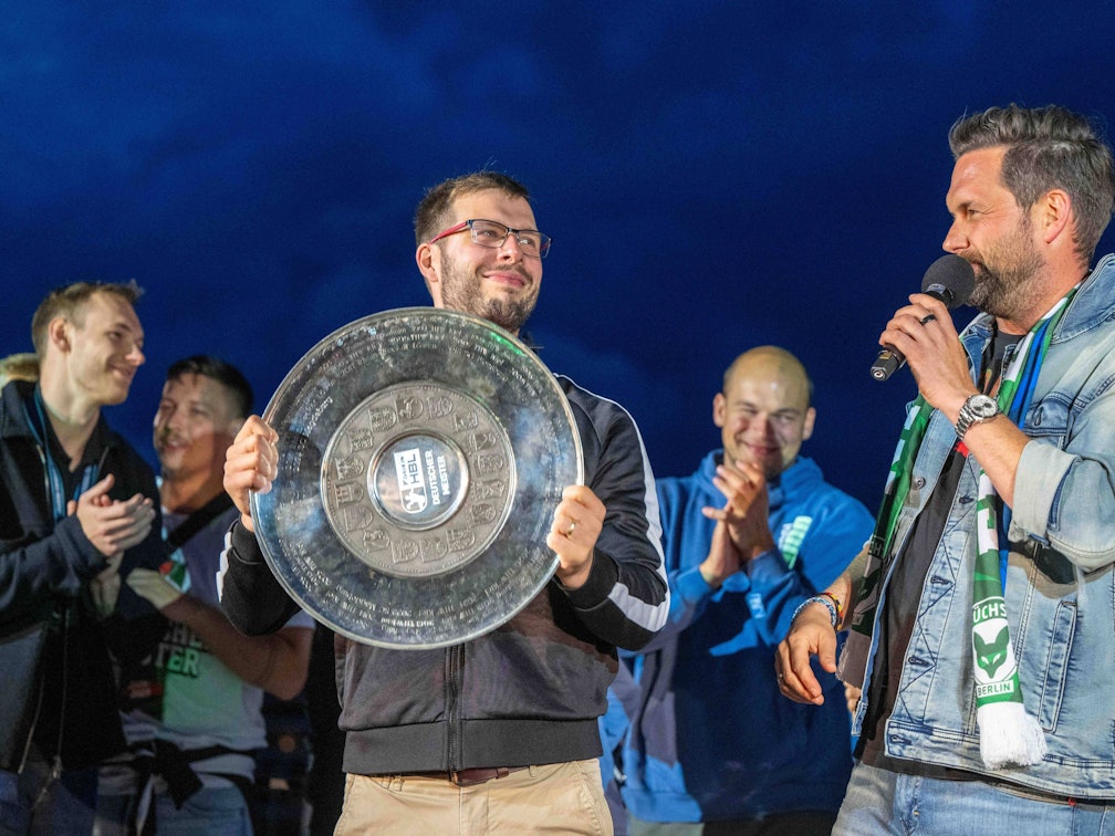 Füchse-Trainer Jaron Siewert präsentiert die Meisterschale der HBL.