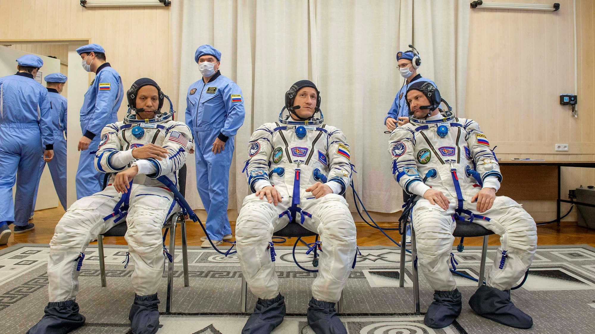 Astronauten Chris Williams, Sergey Kud-Sverchkov und Sergei Mikaev in Raumanzügen