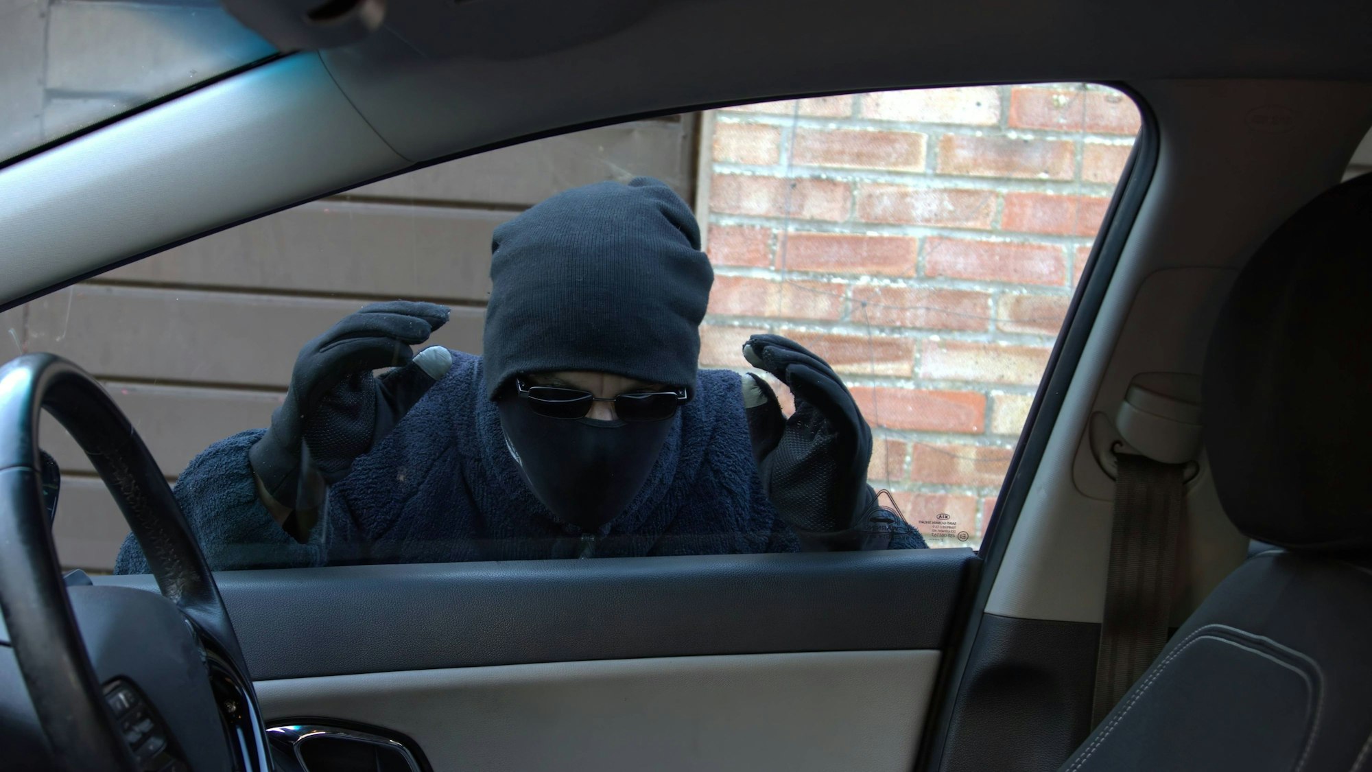 Einbrecher blickt in ein Auto