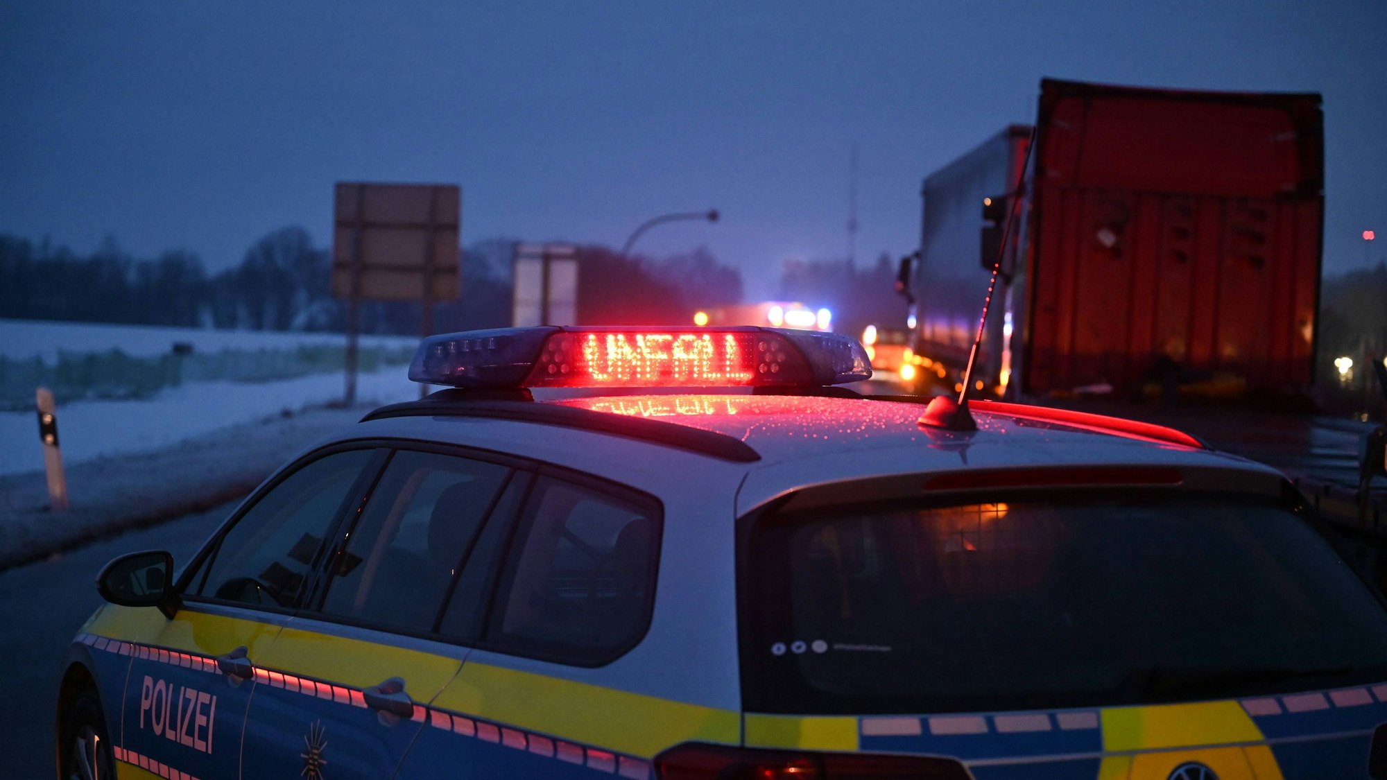 Polizeifahrzeug mit leuchtendem Unfallhinweis auf der Straße