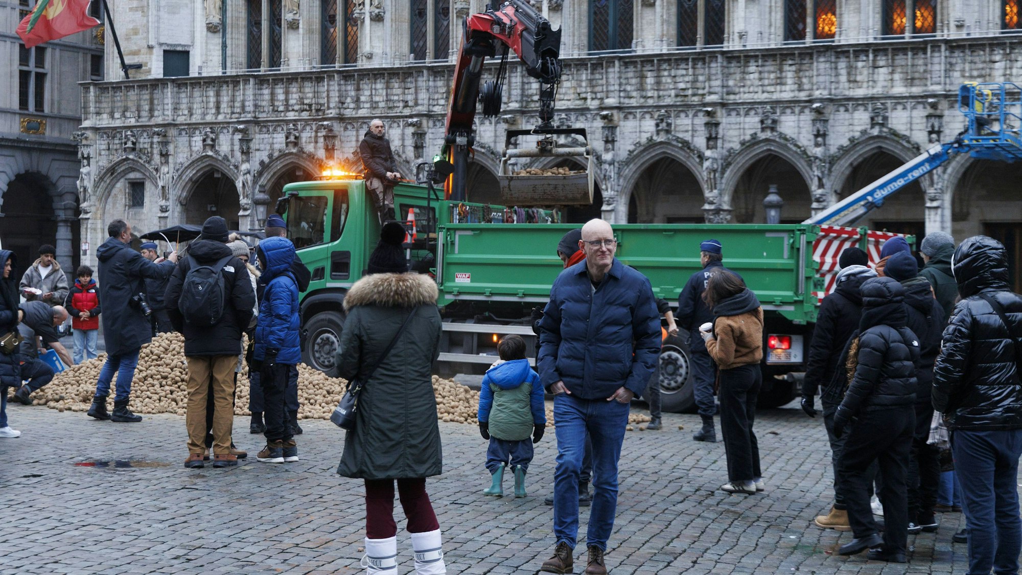 Menschen entladen Kartoffeln von einem LKW auf einen Platz