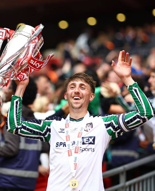 Dan Neil jubelt nach dem Aufstieg mit Pokal.