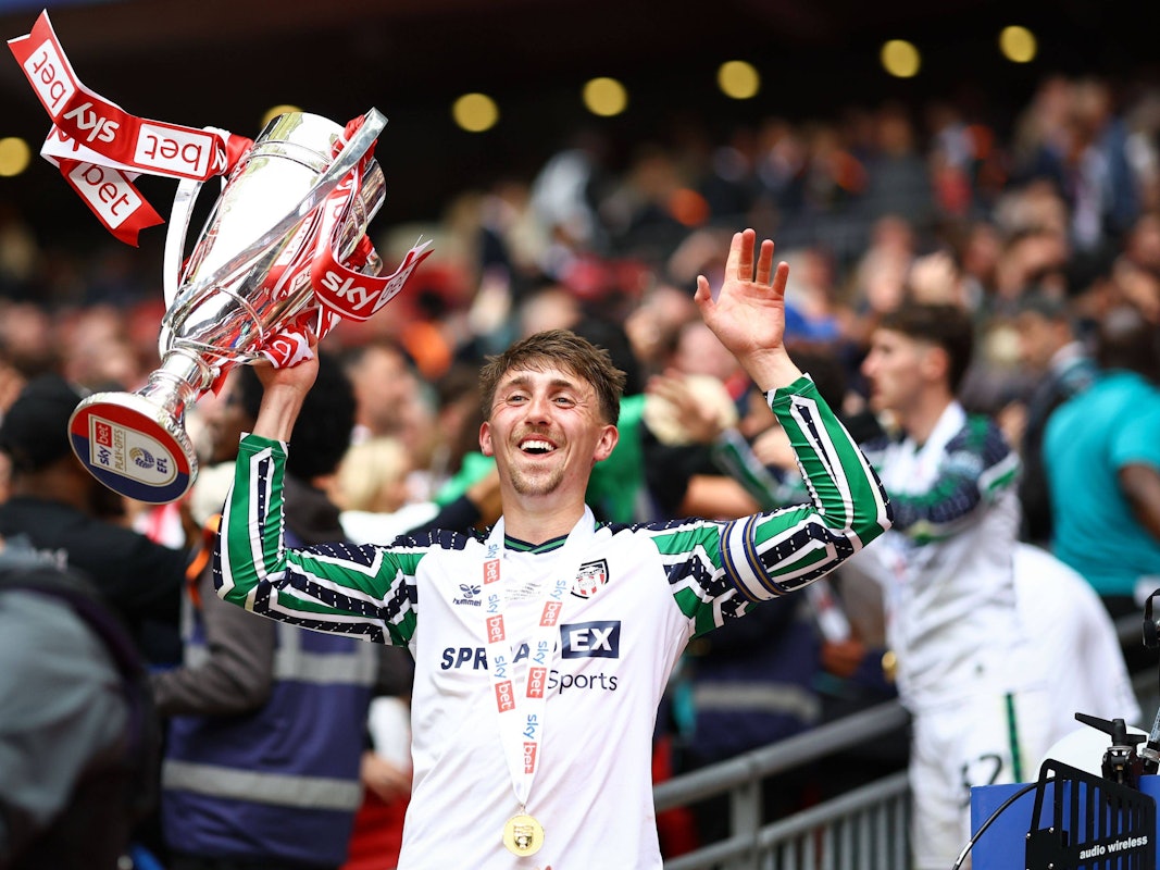 Dan Neil vom AFC Sunderland jubelt mit einer Trophäe in der Hand.