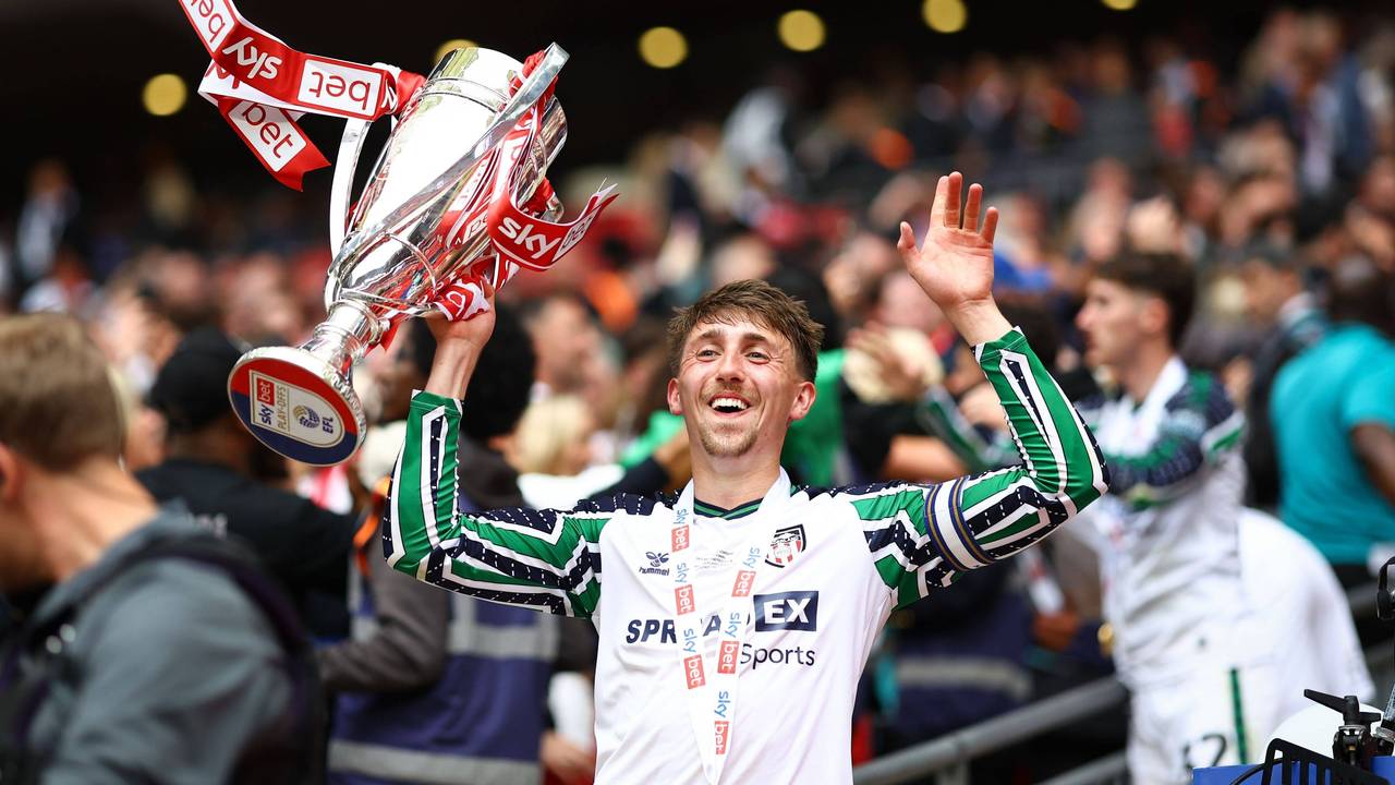 Dan Neil jubelt nach dem Aufstieg mit Pokal.