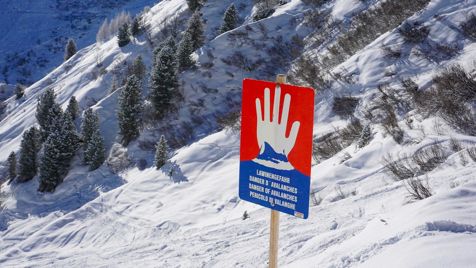 Lawinenwarnschild in schneebedeckter Bergwelt