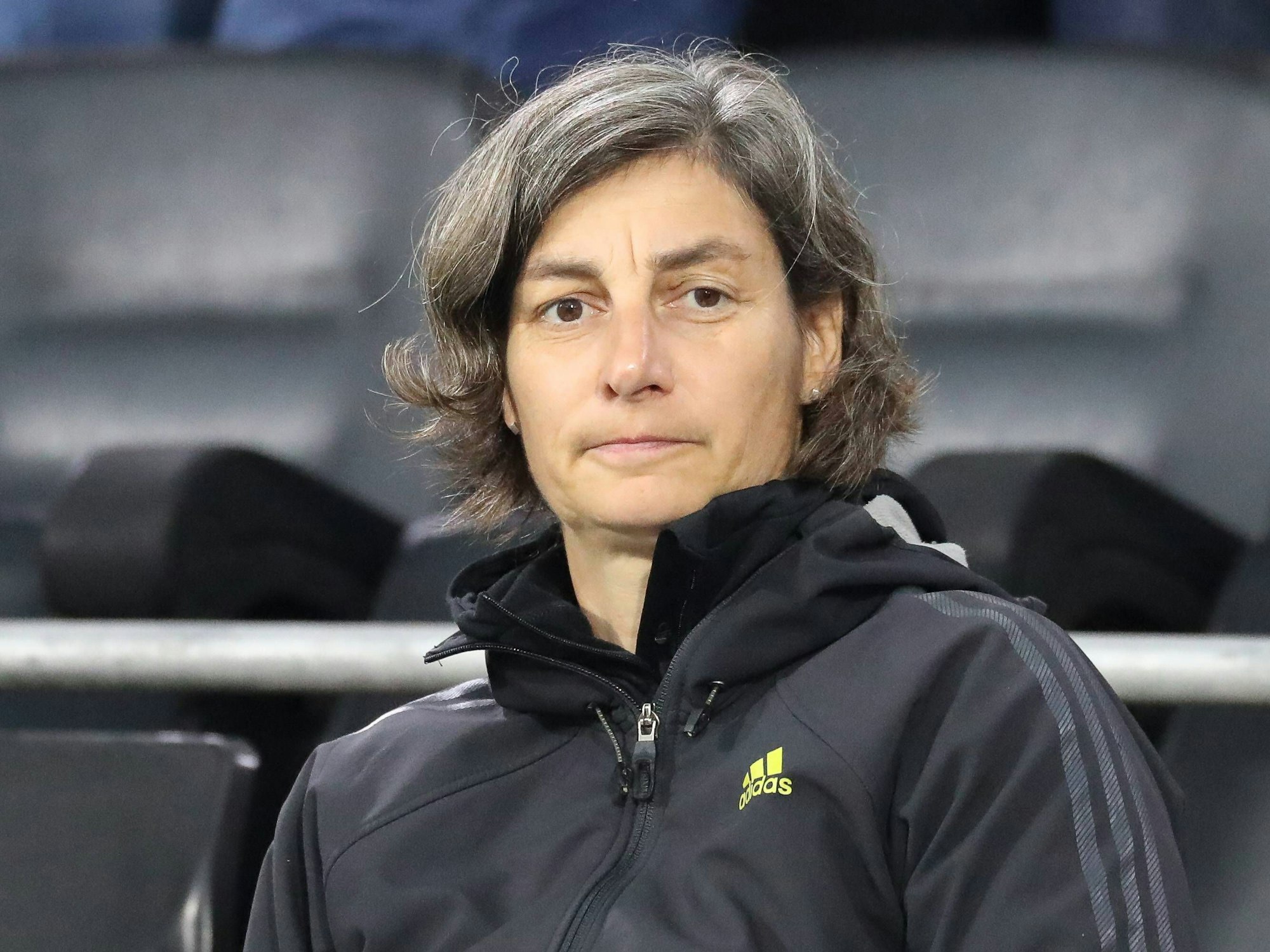Anouschka Bernhard sitzt auf der Tribüne.