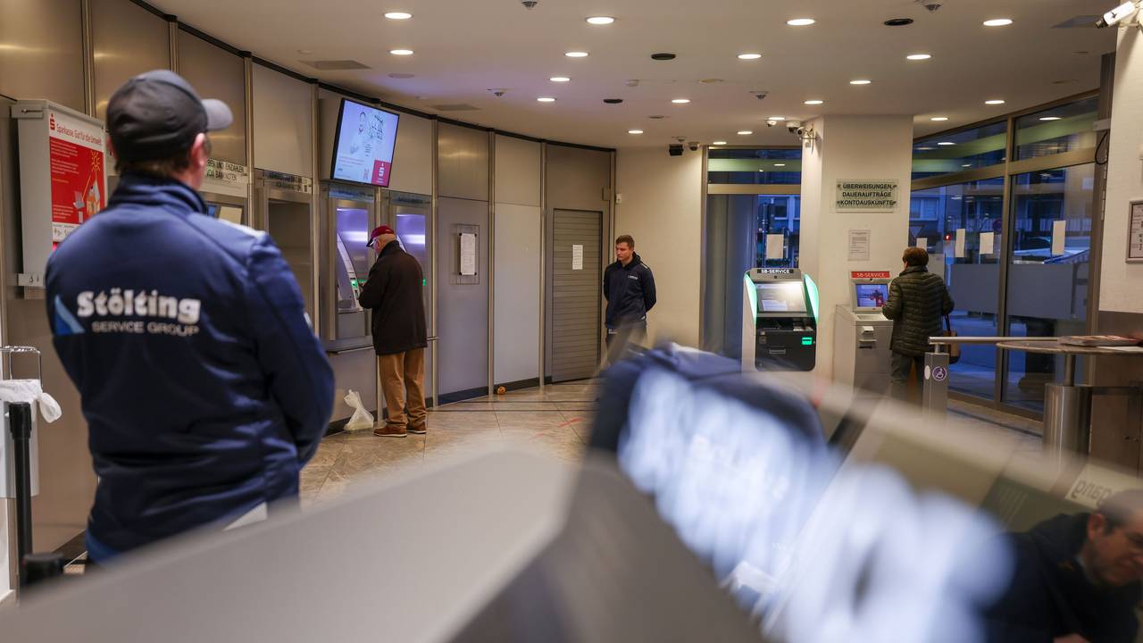 Mitarbeiter einer Sicherheitsfirma stehen im nun wieder geöffneten SB-Bereich der Sparkassenfiliale, in dem sich Kunden nun wieder Bargeld und Kontoauszüge holen können. Gut zwei Wochen nach dem Millionen-Einbruch ist das Foyer der Sparkasse Gelsenkirchen wieder offen.