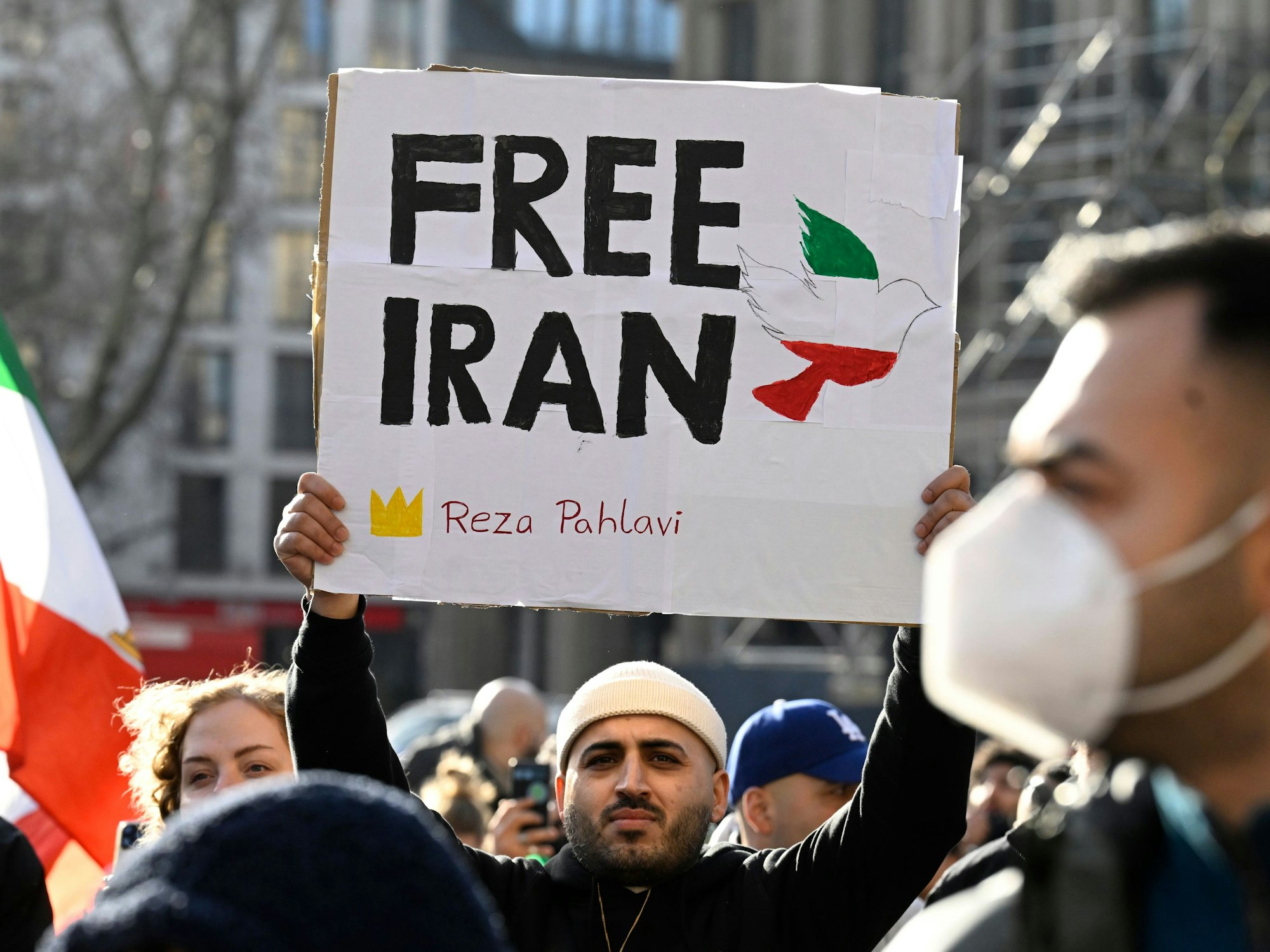 Ein Teilnehmer hält bei einer Demonstration ein Schild mit der Aufschrift Free Iran hoch.