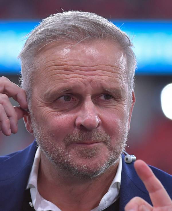 Didi Hamann richtet sich seinen In-Ear-Kopfhörer.