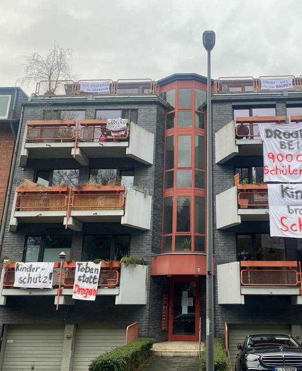 An Balkonen hängen Bettlaken mit Aufschriften wie Kinder brauchen Schutz.