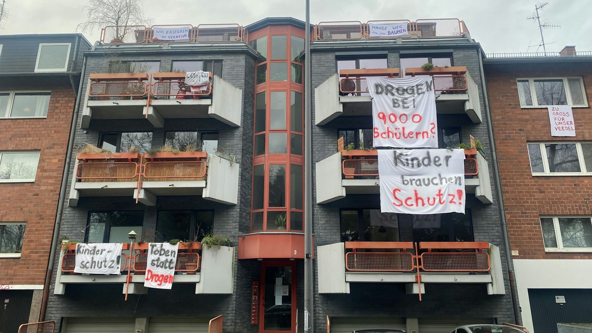 An Balkonen hängen Bettlaken mit Aufschriften wie Kinder brauchen Schutz.