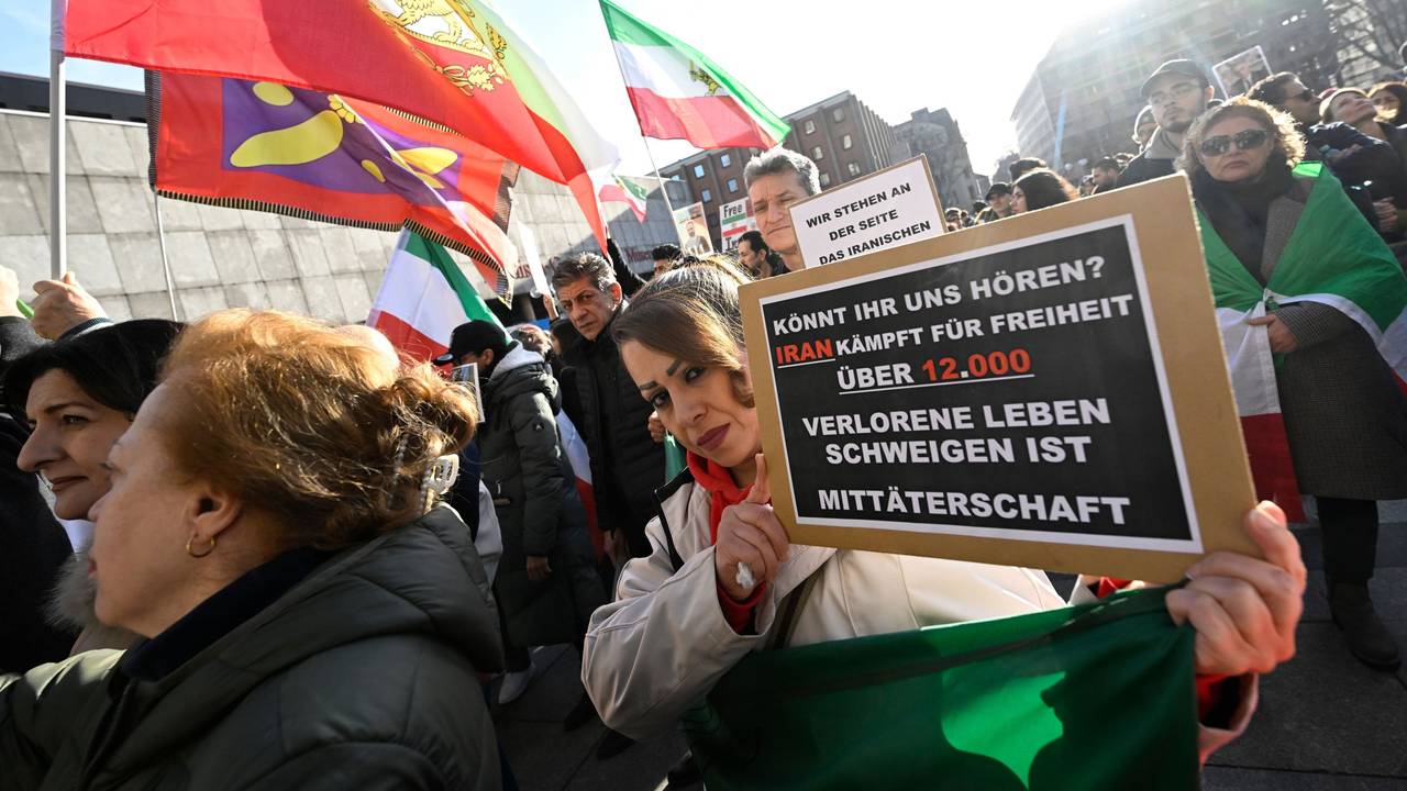 Teilnehmer halten bei einer Demonstration Schilder und Fahnen zur Unterstützung der Proteste im Iran.