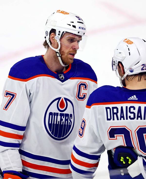 Connor McDavid spricht auf dem Eis mit Leon Draisaitl.