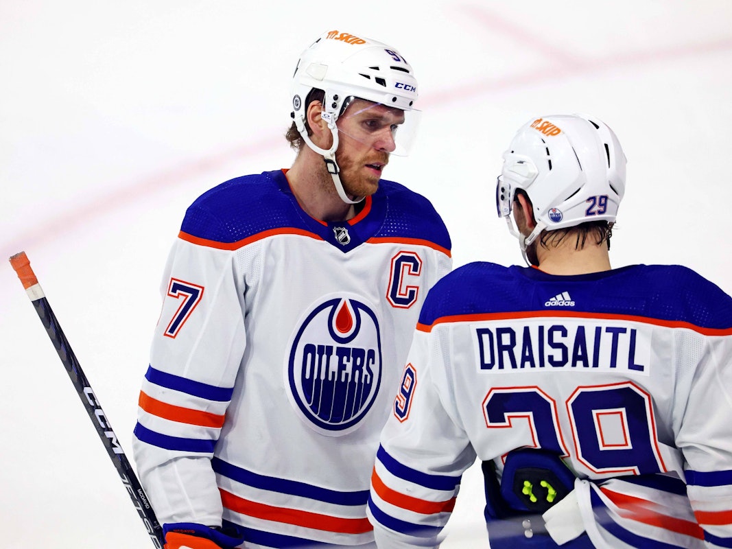 Connor McDavid spricht auf dem Eis mit Leon Draisaitl.