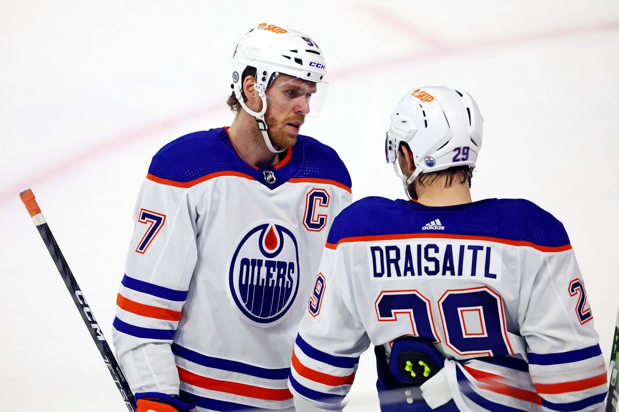 Connor McDavid spricht auf dem Eis mit Leon Draisaitl.