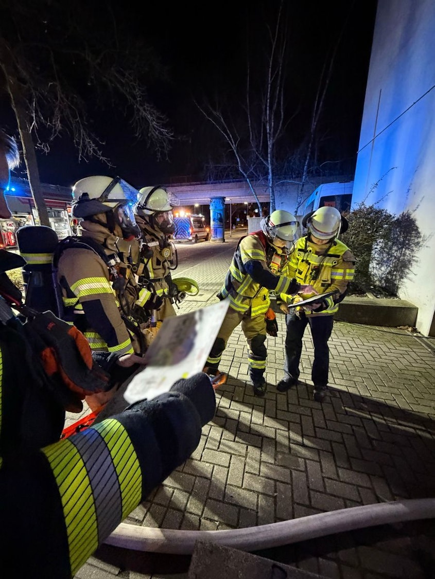 Feuerwehreinsatz in Neuss. Ein Feuerwehrmann steht vor einem verrauchten Eingang.