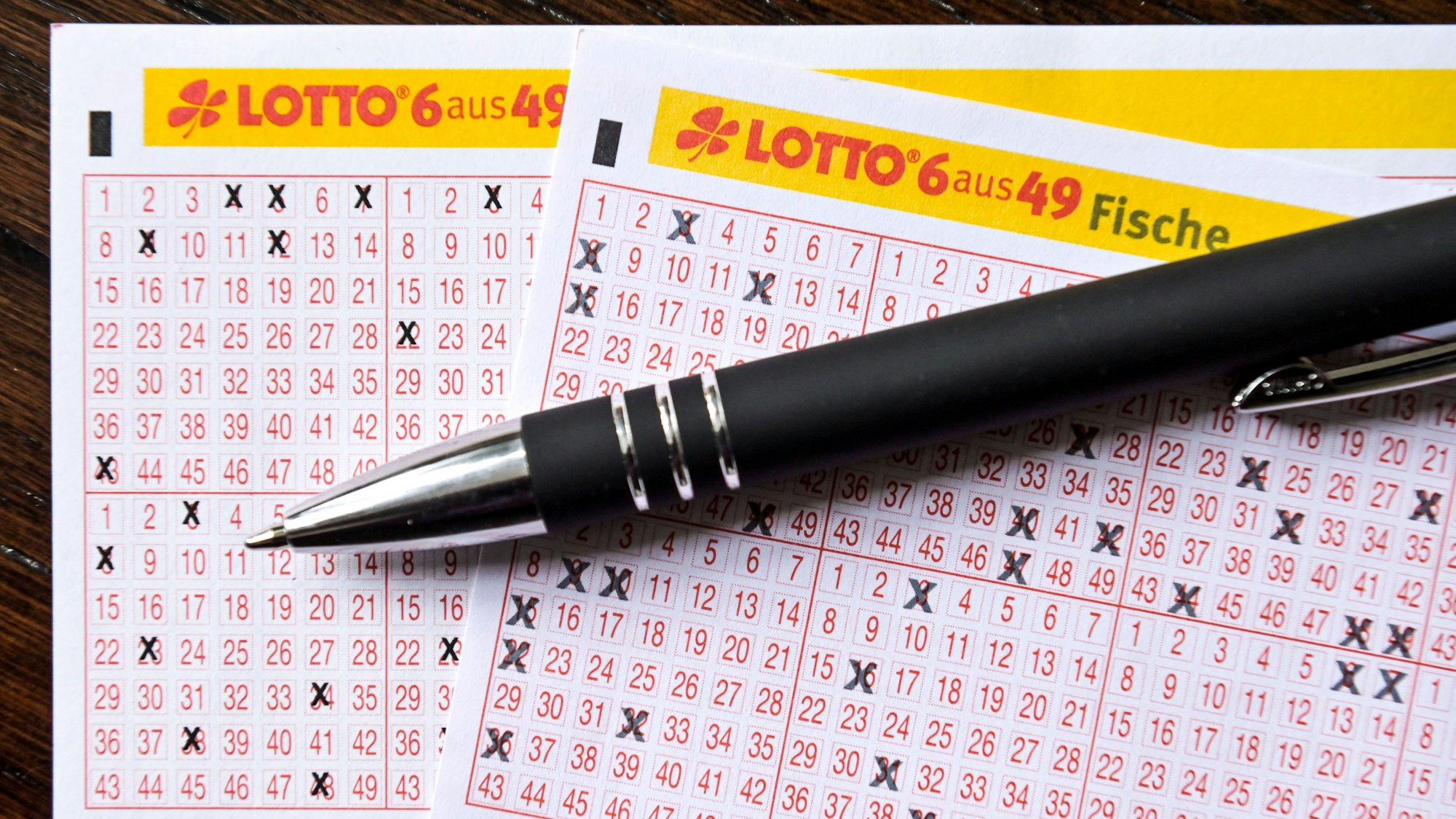 Mehrere Spielscheine mit einem Stift