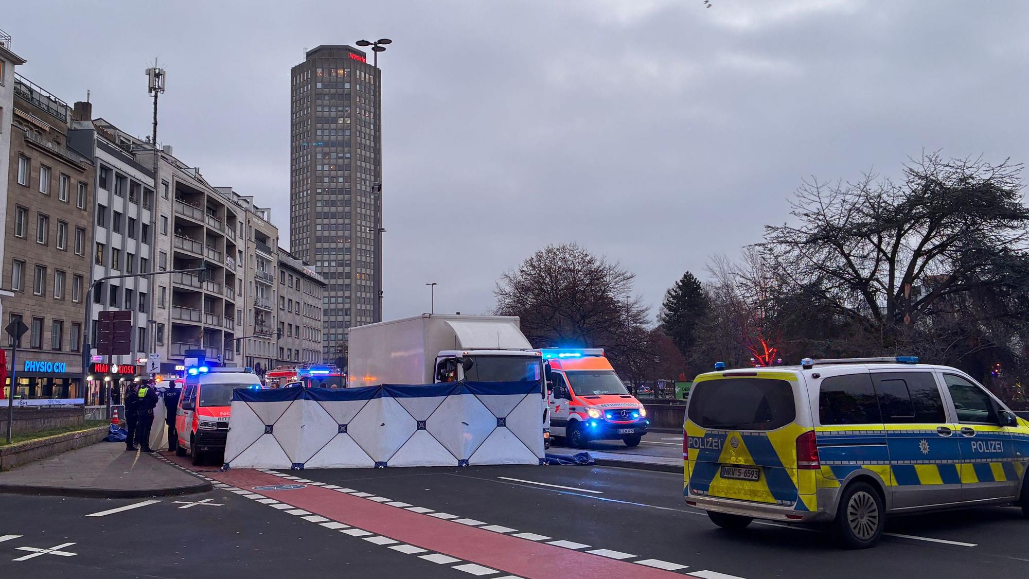 Einsatzfahrzeuge von Polizei und Rettungsdienst stehen an einem Unfallort. Dort ist ein Sichtschutz errichtet worden.