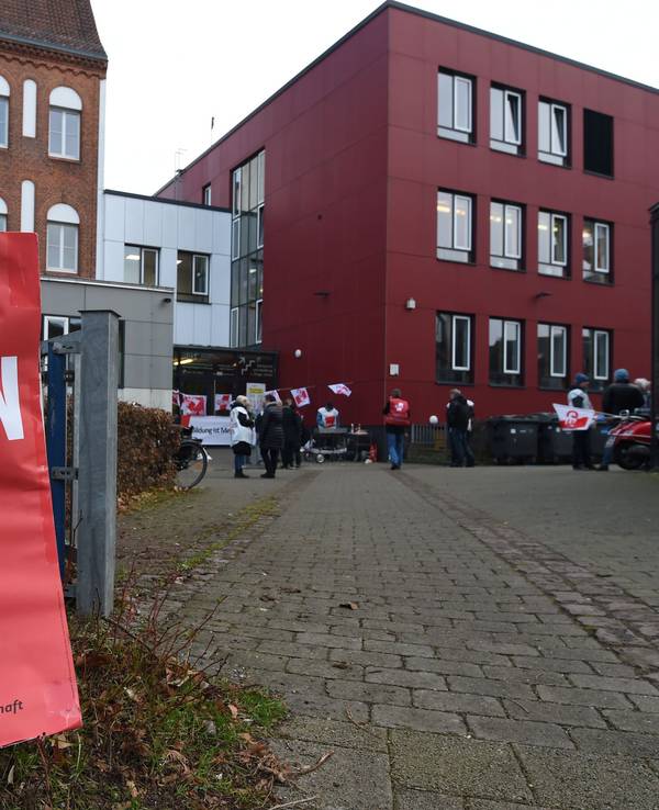Ein Schild mit "Wir Streiken" lehnt am Eingang zur "Allgemeine Berufsbildende Schule" am Steffensweg an einem Baum.