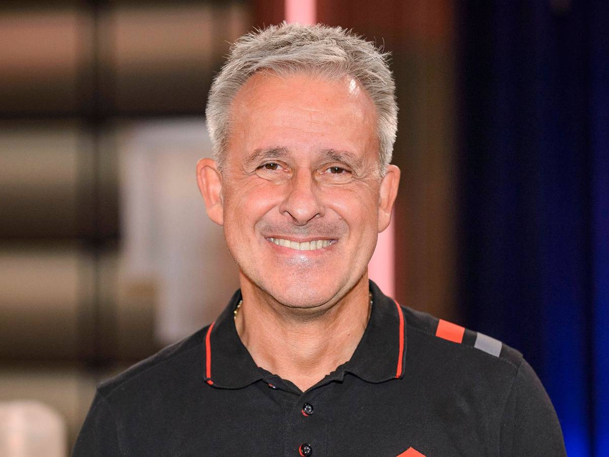 Pierre Littbarski lächelt für ein Foto in die Kamera.