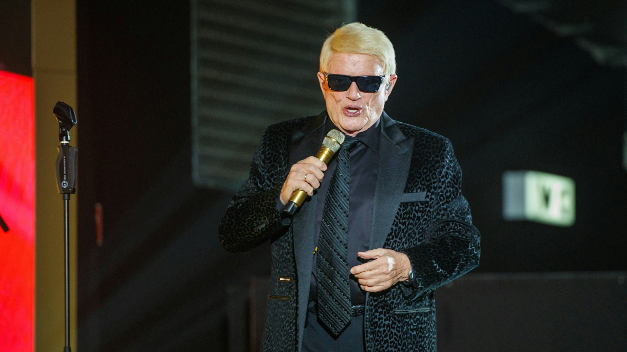 Heino singt auf der Bühne mit Mikrofon