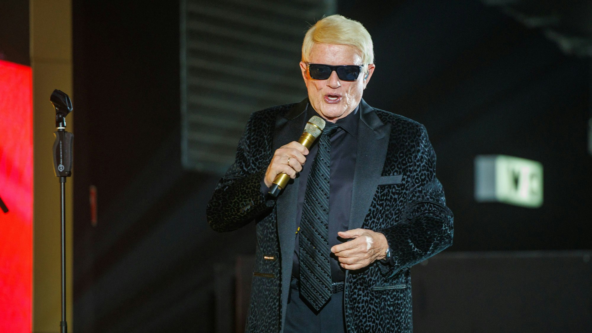 Heino singt auf der Bühne mit Mikrofon