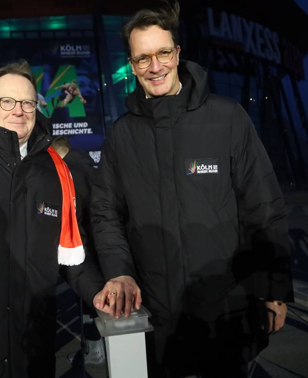 Ministerpräsident Hendrik Wüst (r.) und OB Torsten Burmester drücken symbolisch einen Knopf, der zeitgleich Lichtinstallationen an markanten Orten in NRW aktiviert.