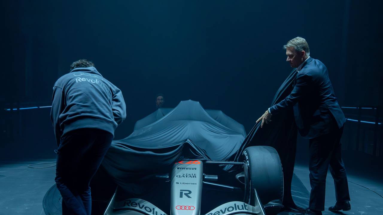 Gernot Döllner (r), Vorstandsvorsitzender der Audi AG, und ein Mitarbeiter ziehen die Plane von dem Formel-1-Rennwagen R 26 von Audi Revolut, der während der Vorstellung des Fahrzeuges im Kraftwerk Mitte auf einer Bühne steht.