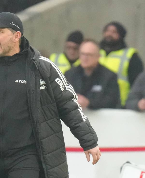Steffen Baumgart schreit etwas von der Seitenlinie auf den Platz, dabei trägt er eine schwarze Jacke.