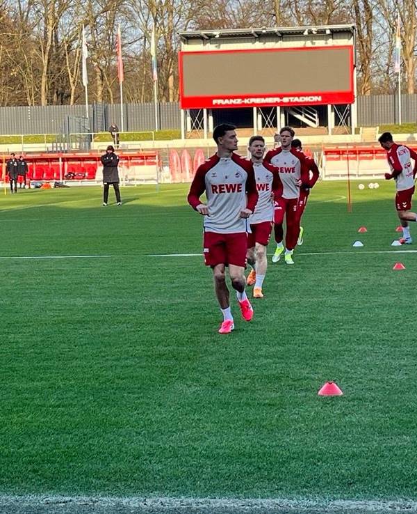 Eric Martel und Florian Kainz laufen sich im Franz-Kremer-Stadion mit ihren Teamkollegen warm.