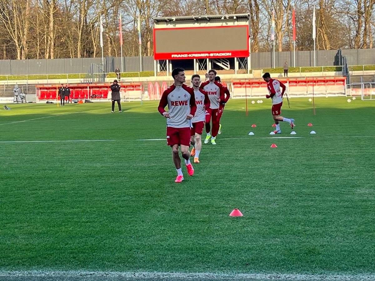 Eric Martel und Florian Kainz laufen sich im Franz-Kremer-Stadion mit ihren Teamkollegen warm.