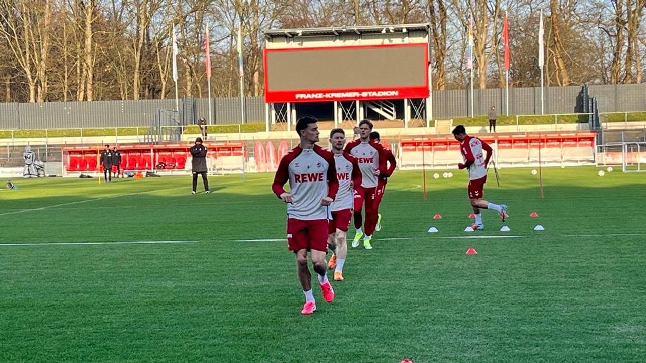 Eric Martel und Florian Kainz laufen sich im Franz-Kremer-Stadion mit ihren Teamkollegen warm.