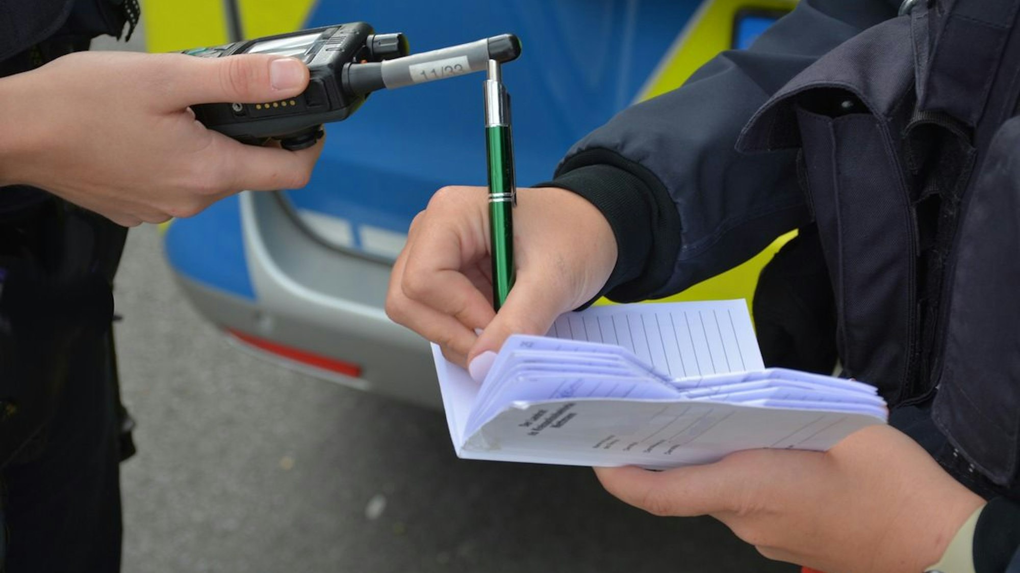 Ein Polizeiauto mit Blaulicht steht vor einer Absperrung.