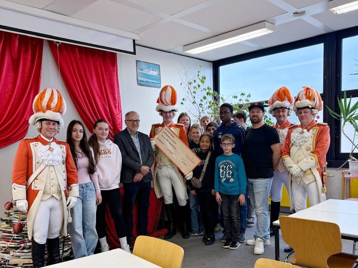 Die Nippeser Bürgerwehr bei der Scheckübergabe in der Gesamtschule.