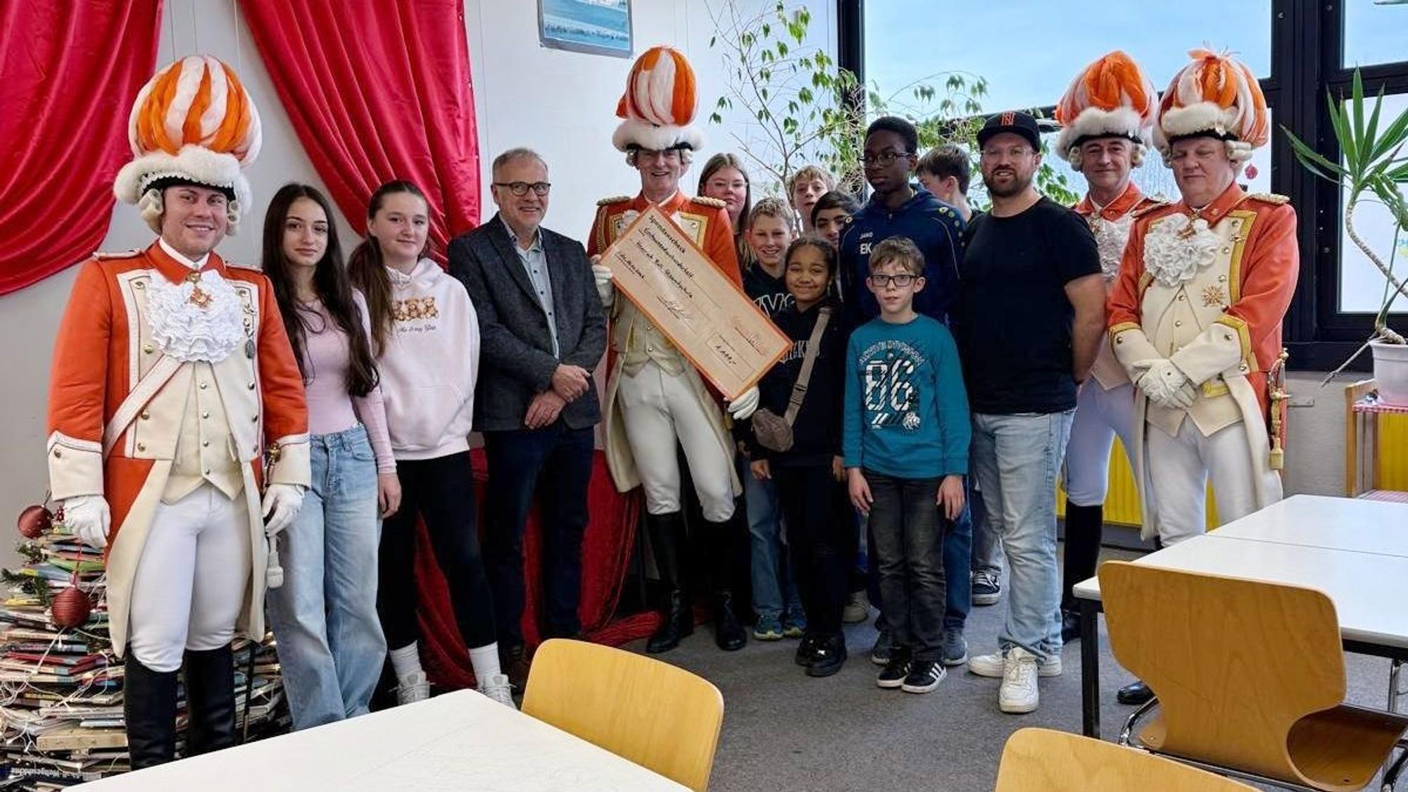Die Nippeser Bürgerwehr bei der Scheckübergabe in der Gesamtschule.