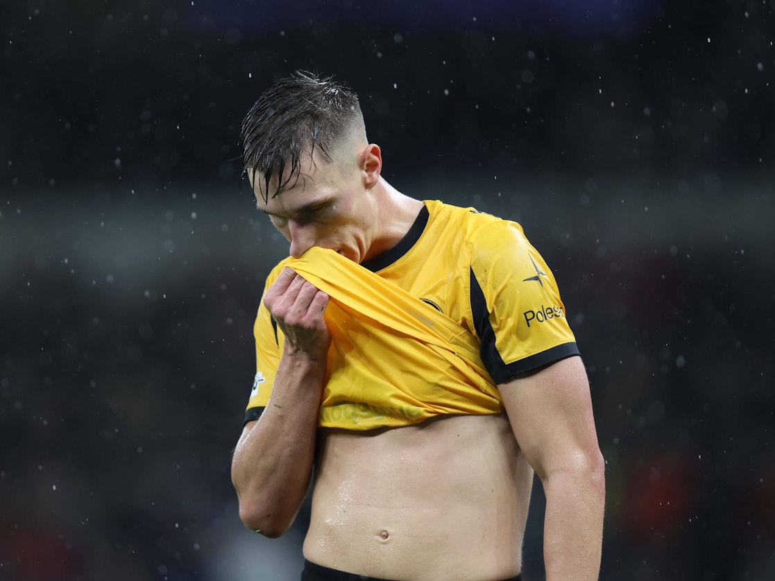 Nico Schlotterbeck wischt sich mit seinem Trikot im Regen über den Mund.