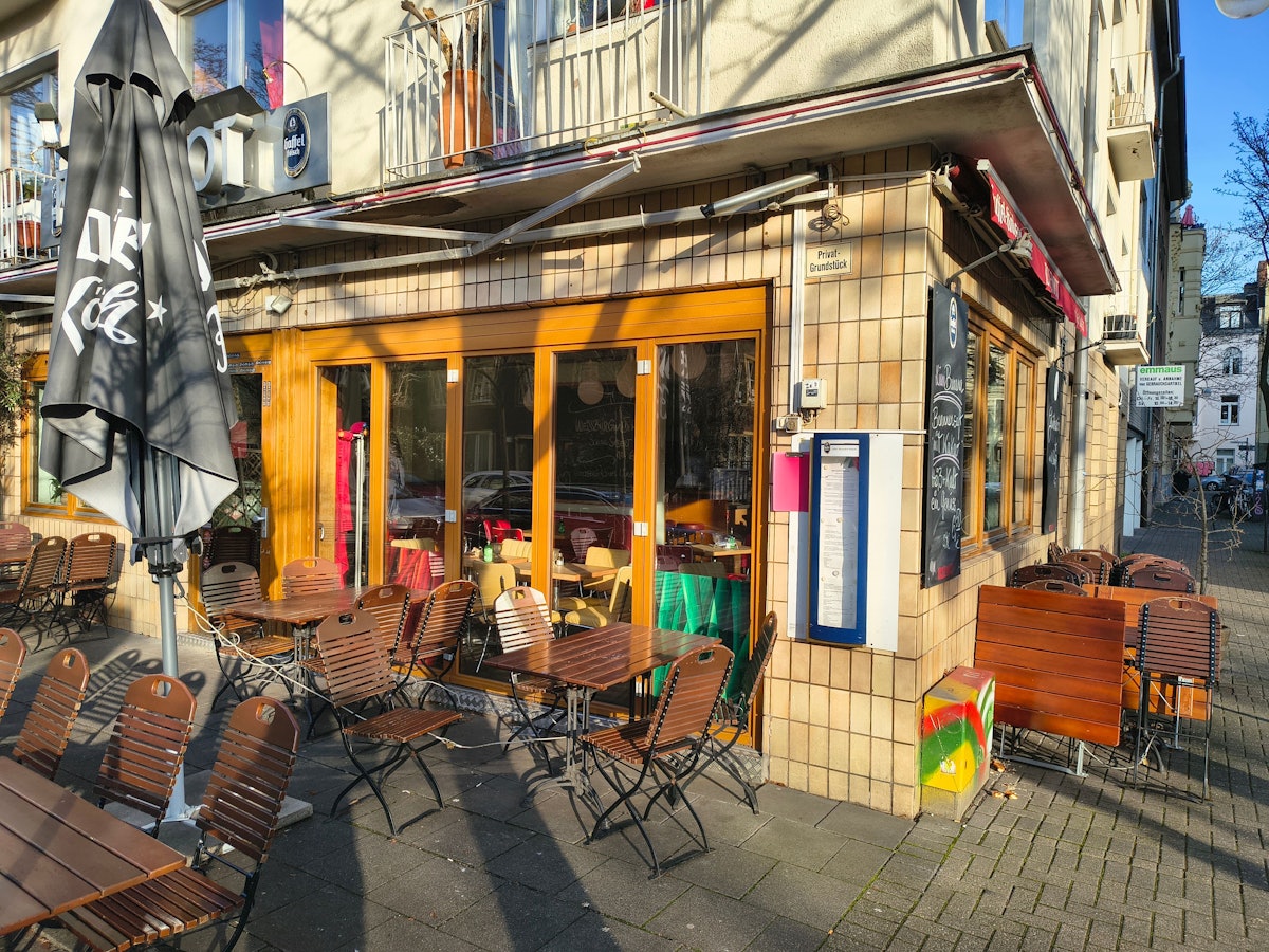 Vor einem Restaurant stehen Stühle und Tische