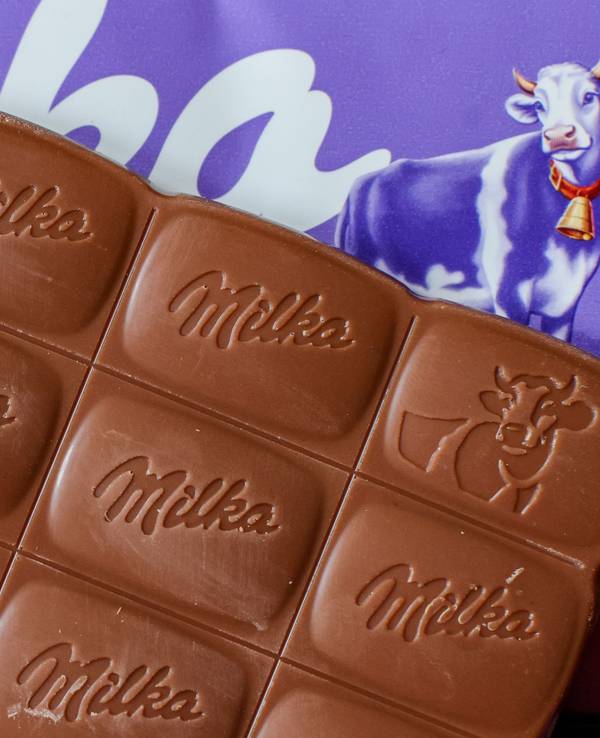 Eine Tafel Alpenmilch-Schokolade von Milka liegt auf einem Tisch.